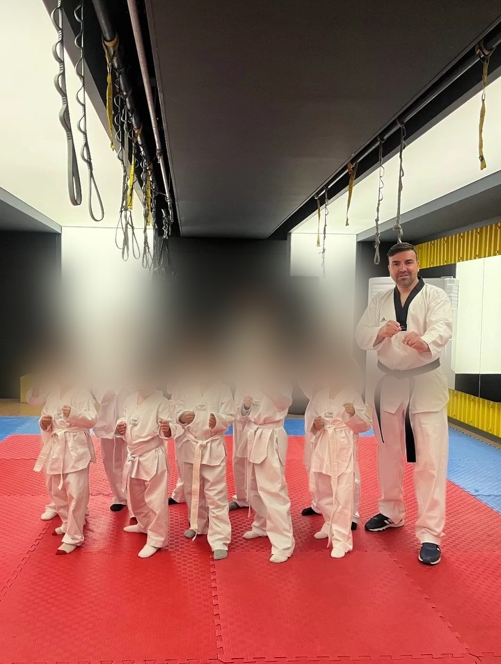 Osman Akınay çocuklara Taekwondo dersi veriyor (öğrencilerin yüzleri gizlilik için bulanıklaştırıldı)